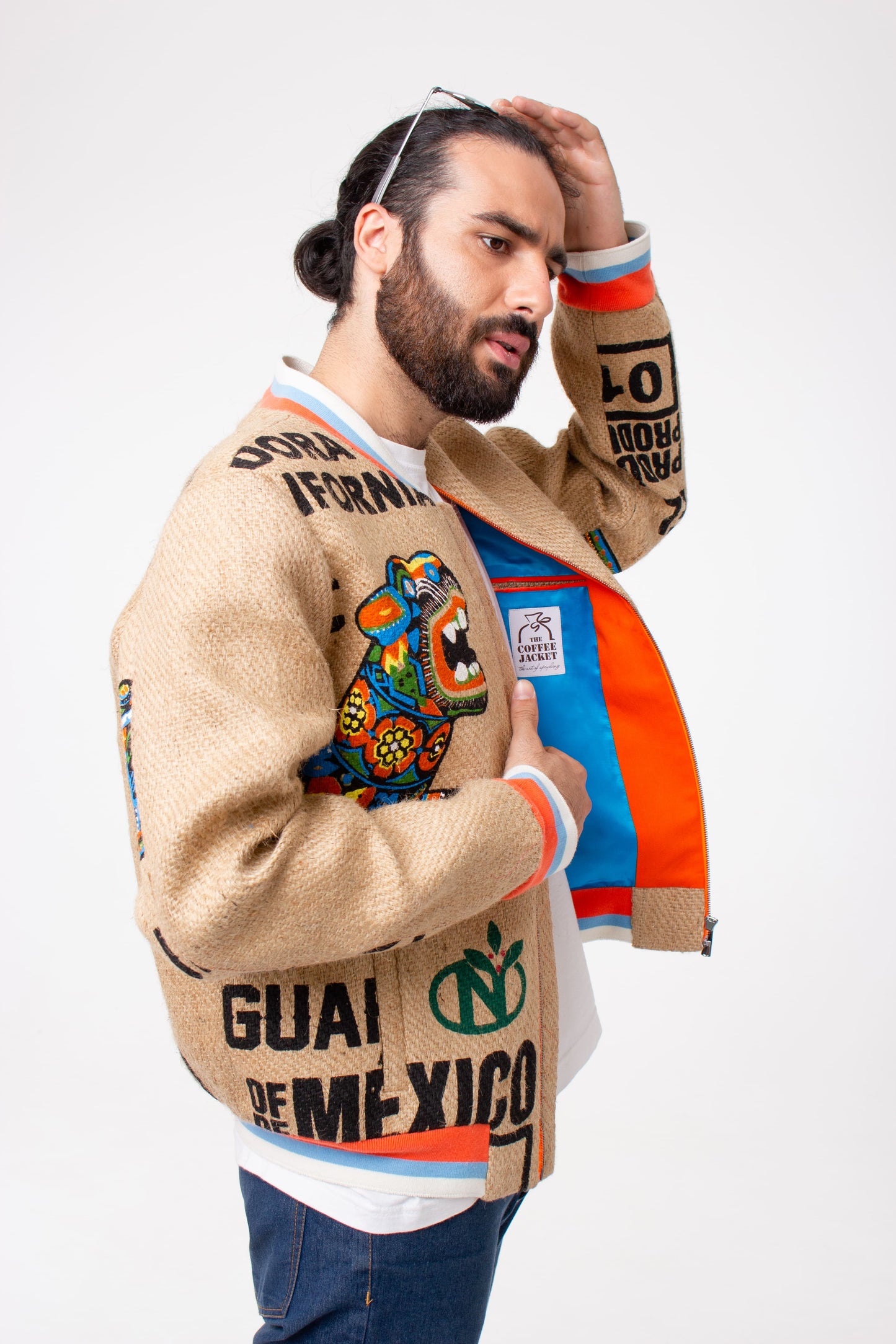 A young man wearing an eco-friendly college jacket from The Coffee Jacket® - a German sustainable outerwear brand