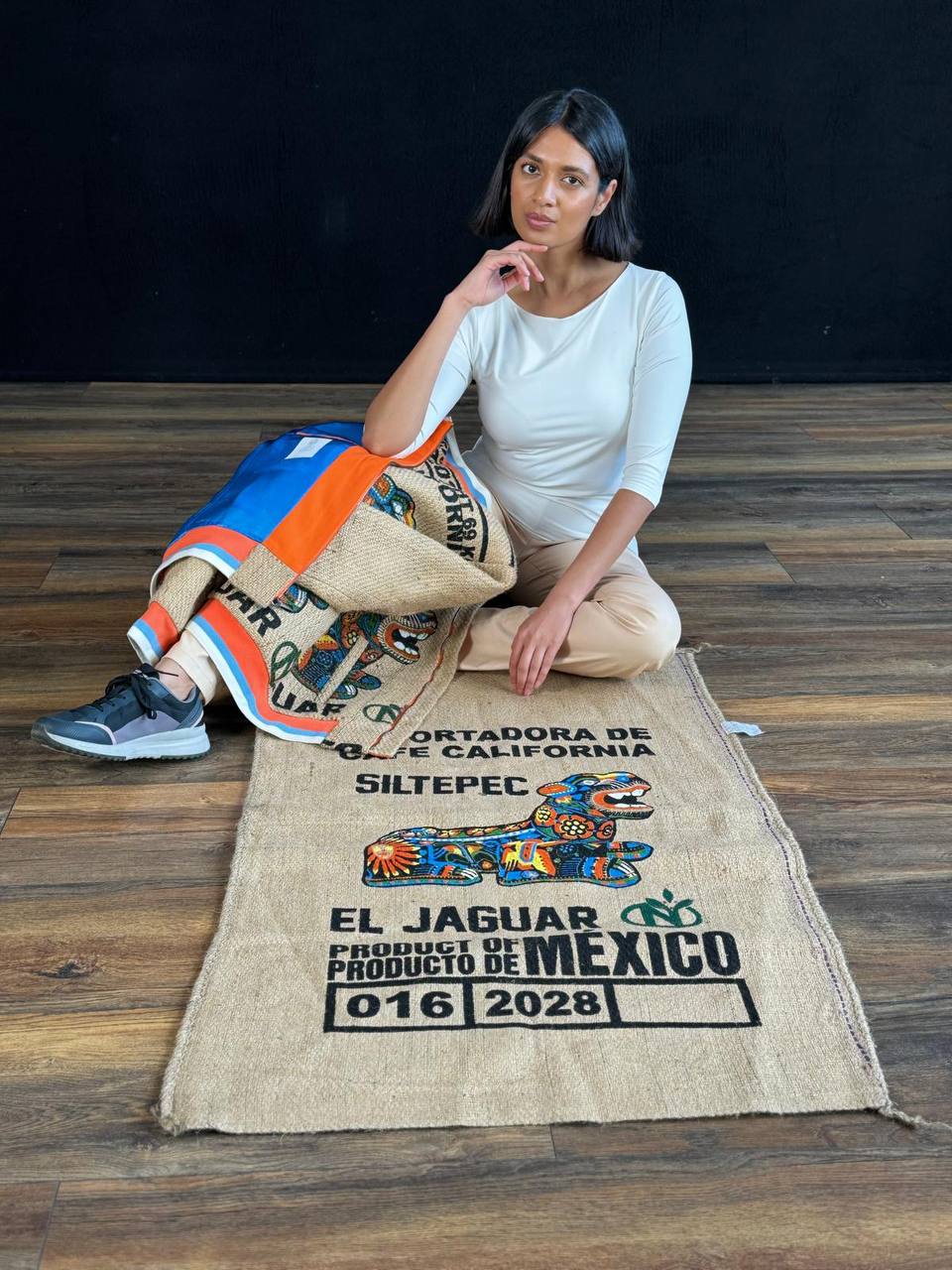 Young lady showing a rare Mexican coffee sack with a stunning JAGUAR print which her eco jacket is made of