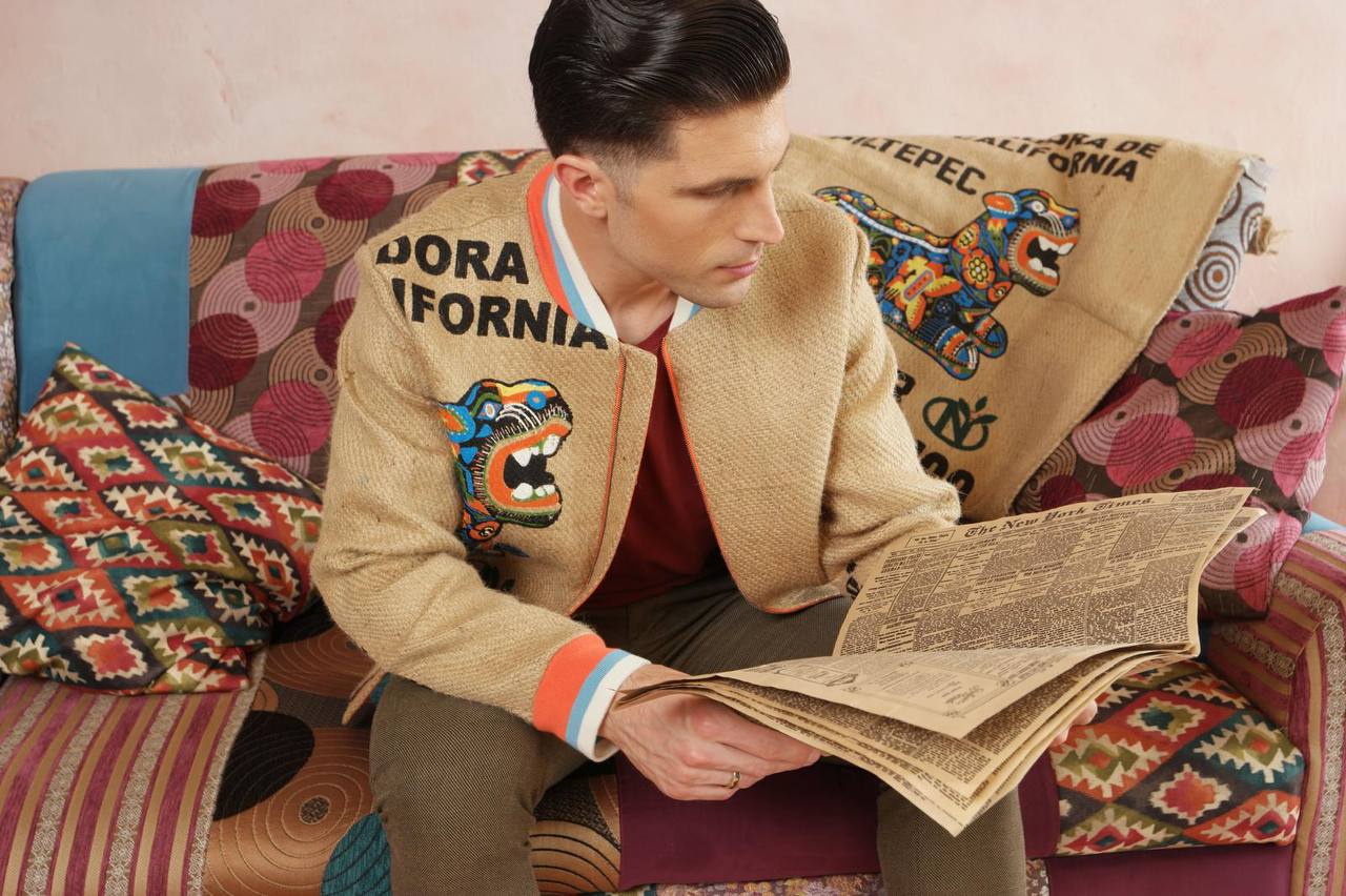 A man reading a newspaper and wearing The College Jacket JAGUAR - extraordinary men`s and women`s upcycling jacket made from coffee sacks with original coffee farm`s print