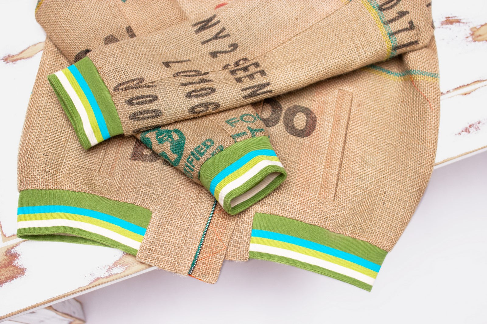 Nachhaltig wiederverwerteter Kaffeesack als Außenmaterial, Spitzendesign mit dem authentischen Print der Kaffeefarm - es ist eine nachhaltige Unisex Bomberjacke von THE COFFEE JACKET®